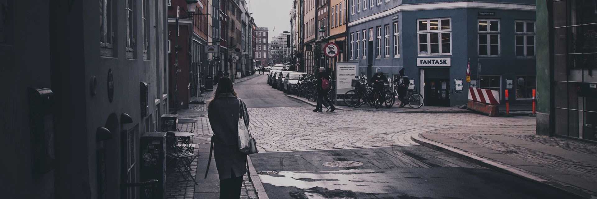 Et vejkryds i København, med fodgængere og en afspærring på grund af vejarbejde.